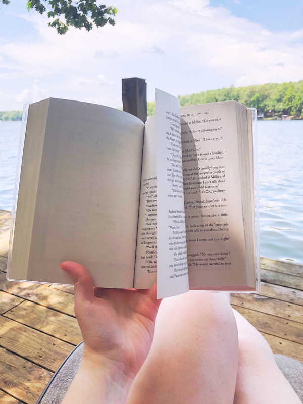 An open book in front of a lake
