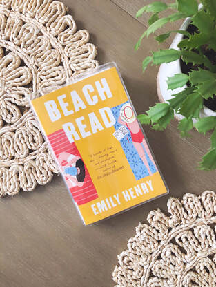 Lay flat of Beach Read by Emily Henry on a table with a succulent